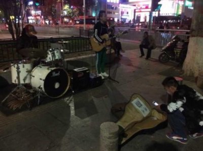 郑州歌手街头唱《关于郑州的记忆》 过往行人微信扫码打赏